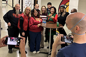 Photo of staff gathering around a small table in a hallway