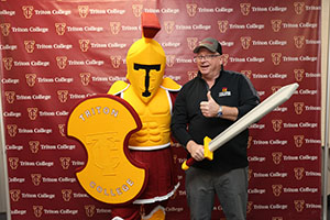 Troy the Mascot posing with Alumni Member