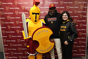 Troy the Mascot posing with President Moore and Alumni Member
