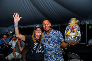 Raffle winner receiving his gift from alumni board member