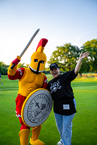 Troy the mascot and alumni board member on golf course