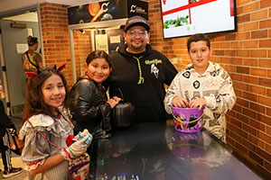 Family dressed in costume for Halloween at Trunk or Treat in space in the Cernan Center