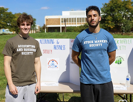 Photo of students posing in front of an information board