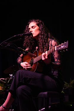 Photo of Maura Wolf playing guitar