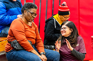 Photo of President Moore visiting Basketball fans in the bleachers