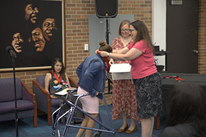 Photo of Hillary Meyer putting necklace on student