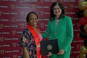 Photo of President presenting WEI certificate to a graduate